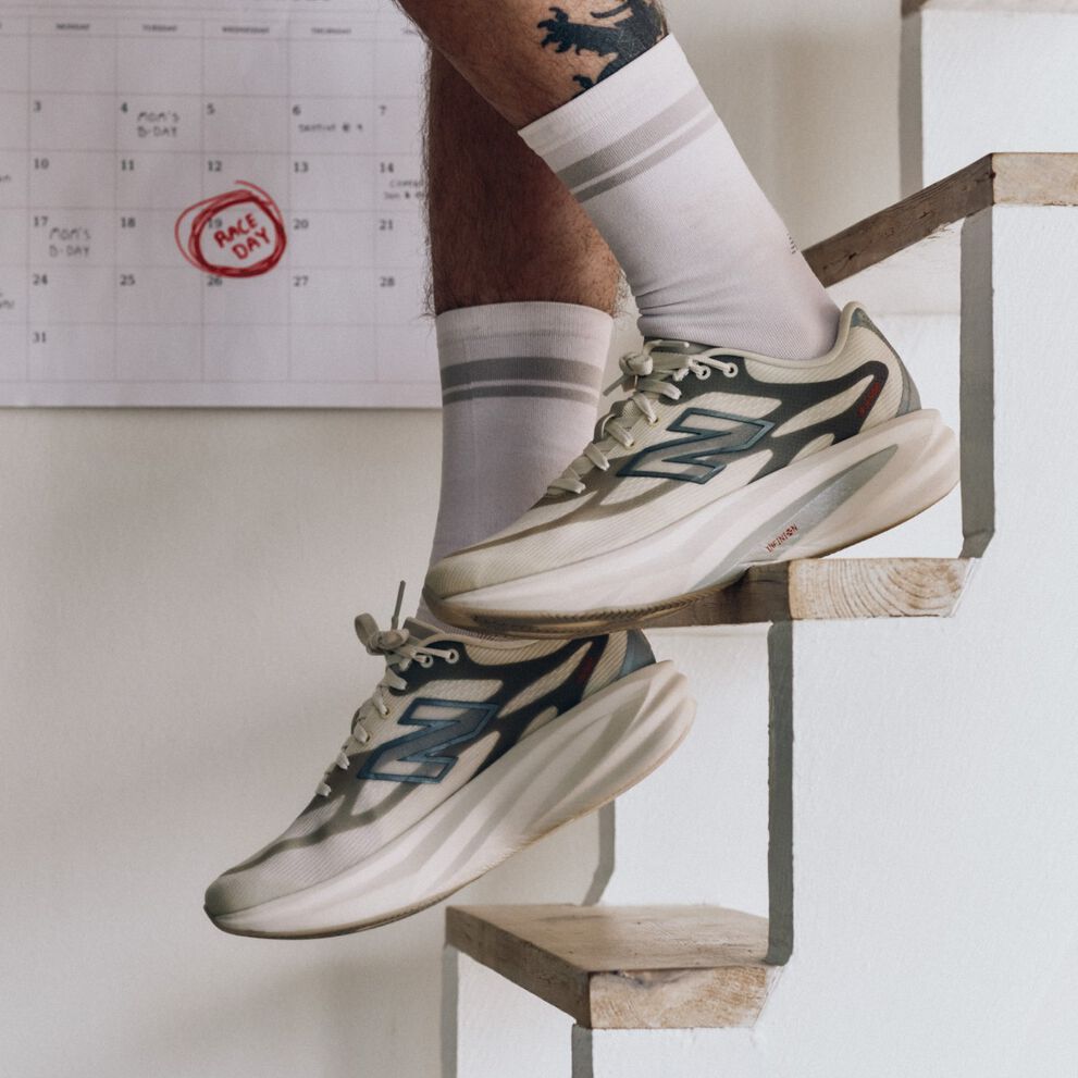 Close up of someone descending stairs in New Balance running shoes.